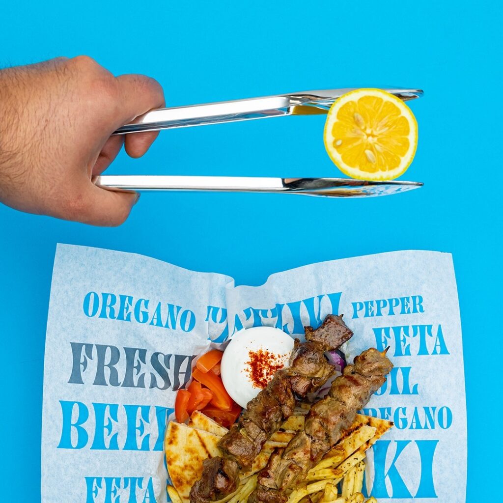 Souvlaki and lemon on branded paper